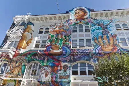 A colorful, large-scale mural covers the side of the Women's Building in San Francisco's Mission District.